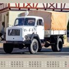 05/2027. Ein alter weißer LKW mit Plane steht vor einem Fachwerkhaus; Kalenderansicht Mai.