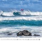 Kalender mit Monatsübersicht für Februar. Wellen, Surfer mit rotem Segel, stürmisches Meer, bewölkter Himmel, Felsen im Vordergrund.