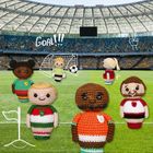 Text: "Goal!!" und Zeichnung einer Siegespose. Im Stadion stehen sechs gestrickte Puppen in Fußballtrikots.