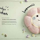 "Romantisches Blümchen" und andere Worte umgeben ein gehäkeltes, lächelndes Kissen in Blumenform, umrahmt von echten Blumen.