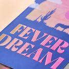 Große Buchstaben "FEVER DREAM" in Pink auf Blau. Im Hintergrund eine Wüstenlandschaft mit Kakteen und einem Pferd.