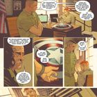 Ein Soldat spricht mit einem anderen in einem Büro. Ein rundes Schild mit einem Stern liegt auf dem Tisch.