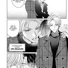 Zwei junge Männer stehen eng beisammen, einer flüstert dem anderen zu. Beide tragen modische Kleidung.