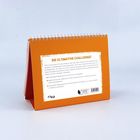 Ein aufgestellter Kalender mit orangefarbenem Karton. Text: "DIE ULTIMATIVE CHALLENGE!" und Informationen zu Workouts.