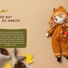 „Alma und der Duft des Herbstes“ steht in geschwungener und klarer Schrift neben einer gestrickten Puppe.