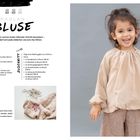 Texte: Raglan-Bluse, Details wie Rüschen, Material, Zuschnitt. Beschreibung: Ein fröhliches Kind trägt eine beige Bluse.