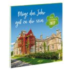 „Möge das Jahr gut zu dir sein“ und „Irische Segenswünsche 2027“ auf einem vierblättrigen Kleeblatt. Darstellung eines großen Herrenhauses mit rotem Efeu.