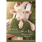 „Der Herr ist mein Hirte, mir wird nichts mangeln. Psalm 23,1.“ Eine Person in Grün hält ein weißes Lamm im Arm.