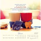 Zwei Tassen mit einem Schal umwickelt, daneben ein Lebkuchenherz. Text: "Jeder Blick, jedes Lächeln... Geschenk der Liebe."