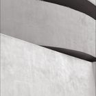 "GUGGENHEIM" in großen Buchstaben, darunter ein Kalender. Zementartige strukturierte Wände mit gebogenen Linien.