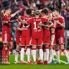 "FEBRUAR" und ein Kalender sind unten links. Fußballspieler in roten Trikots umarmen sich auf dem Spielfeld.