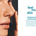"Feel your skin. Neuroglow entdecken. Was Haut und Hirn gemeinsam haben und wie Umwelteinflüsse wirken." Ein Gesicht in Nahaufnahme.