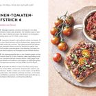AUBERGINEN-TOMATEN-AUFSTRICH. Daneben ein Teller mit Brot, belegt mit dem Aufstrich, und frischen Tomaten.
