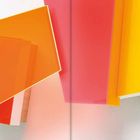 Eine abstrakte Komposition aus überlappenden, farbigen Rechtecken in Orange, Rot, Rosa und Gelb auf hellem Hintergrund.