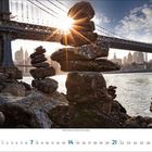 Februar 2022 Kalenderblatt mit Steinmännchen vor einer Brücke im Sonnenuntergang, Stadt im Hintergrund.