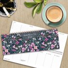 „Mein Planer für 2027“ auf floralem Design. Daneben ein Kaffee, drei Stifte und Blätter auf Holzoberfläche.