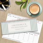 "GROSSDRUCK TISCHKALENDER 2027, 1 Doppelseite = Woche." Kalender auf Holzoberfläche, daneben Kaffee und Stifte.