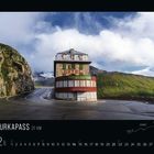 "FURKAPASS 31 KM" steht unten links. Ein kurvige Straße führt zu einem alten Hotel in den Bergen, umgeben von Wolken.