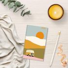 Text "2027" auf einem Notizbuch. Ein Illustrations-Cover mit Sonne und Van. Daneben eine Kerze, ein Bleistift und Eukalyptus.