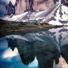 Kalendarium für Februar 2021. Hinter den Daten spiegelt ein klarer See drei markante Berggipfel unter einem dramatischen Himmel.