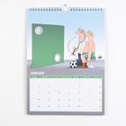 Kalender mit dem Monat Januar. Illustration: Ein Mann mit Arzt untersucht vor einer Torwand mit zwei Löchern.