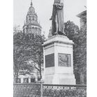 Das Gutenbergdenkmal, von einem Gitter umgeben, 1925. Eine große Statue steht auf einem hohen Sockel, im Hintergrund ein Turm.