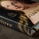 „Dürer“ in goldener Schrift auf einem Buch. Gemälde eines Gesichts mit blondem Haar, darunter „TASCHEN“.