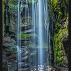 Kalenderseite für Februar, großer Wasserfall im grünen Moos, Kalenderdaten darunter.