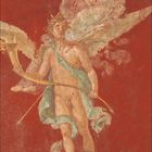 Zahlen unten: 2, 1-28. Eine antike Freskomalerei zeigt einen geflügelten, fast nackten Mann mit Kranz und Mantel vor rotem Hintergrund.