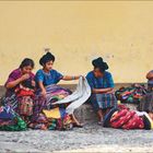 “In Traditionen verhaftet. Antigua in Guatemala...” Kalender für Mai und Juni. Frauen in traditioneller Kleidung sitzen vor gelber Wand.