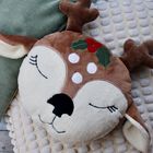 Plüschkissen in Form eines Rentierkopfes mit geschlossenen Augen, rotem und grünem Stechpalmenmotiv auf dem Kopf.