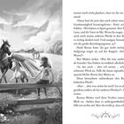 Zwei Flügelpferde, ein Fohlen und ein großes schwarzes Pferd, stehen auf einer Wiese. Ein Mädchen sitzt auf einem Zaun und beobachtet sie.