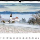 Februar 2021. Winterlandschaft mit Kirche, Bäumen und Nebel in frostiger Umgebung, Berge im Hintergrund.