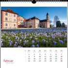 Kalenderseite für Februar 2021. Bild: Ein Gebäude vor einem Feld mit blühenden Krokussen.