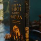 Buchtitel: "There is a Witch in Every Woman". Frauen tanzen vor großem Vollmond, mystische Stimmung.