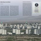"Weiße Häuser in der Wüste", Artikel über Turkmenistan. Bild zeigt eine Stadt mit vielen weißen Hochhäusern in weiter Landschaft.