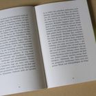 Text auf den Seiten 38 und 39 eines Buches. Das Buch liegt offen auf einem Tisch, daneben liegen weitere gelbe Bücher.