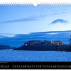 "Februar" und "Festung Königstein zur Blauen Stunde" stehen auf einem Kalender. Die Festung leuchtet im Abendlicht.