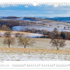 Text: "Winterhauch im Gebirge, Februar". Landschaft mit sanften Hügeln, teils schneebedeckt, vereinzelte Bäume, blauer Himmel.