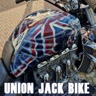 Titel: Union Jack Bike. Text: Bitte über das gesamte Motorrad einen Union Jack malen. Bildbeschreibung: Triumph-Motorrad mit Union Jack-Muster.