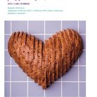 "Kasseler Brot" in lila Schrift, Informationen zur Backzeit und Temperatur. Gezeigtes Brot ist herzförmig geschnitten auf Kacheln.