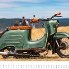 Eine grüne Simson Schwalbe KR51/2 auf einer Wiese. Kalenderseite für August mit einem braunen Sitz.