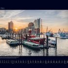 03 März. Hafen mit modernen Gebäuden im Sonnenuntergang, Boote im Vordergrund, Elbphilharmonie sichtbar.