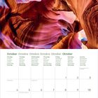 Kalenderseite Oktober, mehrsprachige Wochentage; Bild: bunte, geschwungene Felsformationen mit farbenfrohen Lichtspielen.
