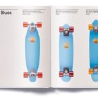 "The Blues" oben, mit drei blauen Skateboards horizontal angeordnet, jeweils mit verschiedenen Rollen und Achsen.