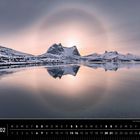 Kalender Februar, Norwegen, Schneeberge spiegeln sich im Wasser. Weiches Licht mit Halo-Effekt über den Bergen.