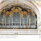 Basilika St. Lorenz in Kempten, Deutschland. Eine prunkvolle Orgel mit goldenen Verzierungen, im Hintergrund ein Kalender.