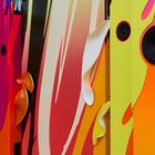 Bunte Lautsprecherinstallation mit geschwungenen Formen und lebhaften Farben in Rot, Gelb und Orange.