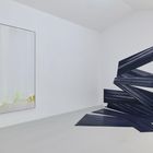 Links ein Gemälde mit vertikalen weißen Linien, rechts eine dunkle, gezackte Wandinstallation. Helle Umgebung.