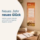 Neues Jahr neues Glück. Wandkalender mit Giraffenmotiv. Tisch mit Notizbuch, Stift, Tasse und Bücher.